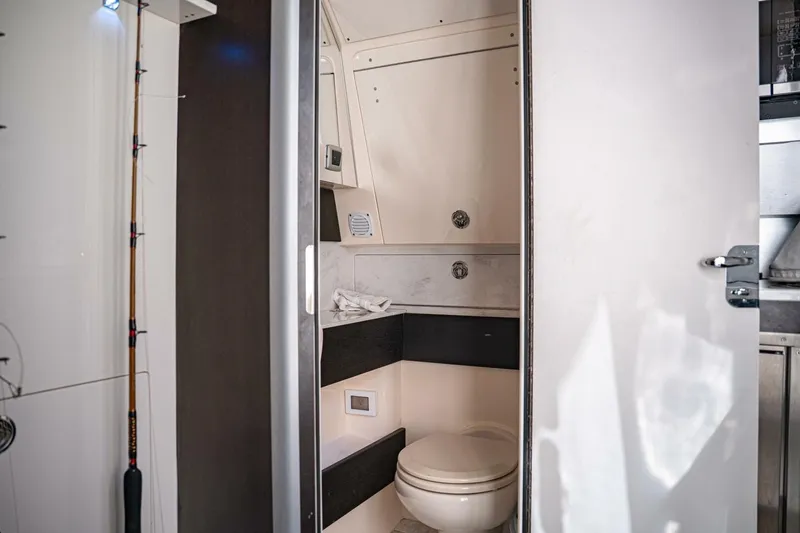 Slide: The Image of 2020 Scout 380 LXF boat interior bathroom with modern design and fishing rod storage. - 19