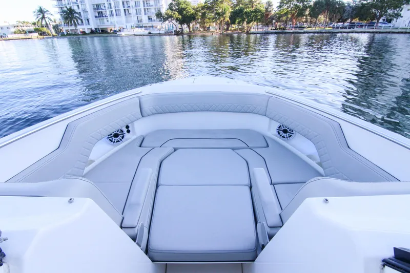 Slide: The Image of 2023 Pursuit DC 295 Dual Console boat interior with luxurious seating on calm water. - 10