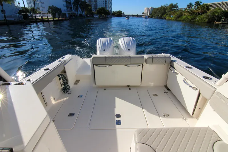 Slide: The Image of 2023 Pursuit DC 295 Dual Console boat on a scenic waterway. - 12