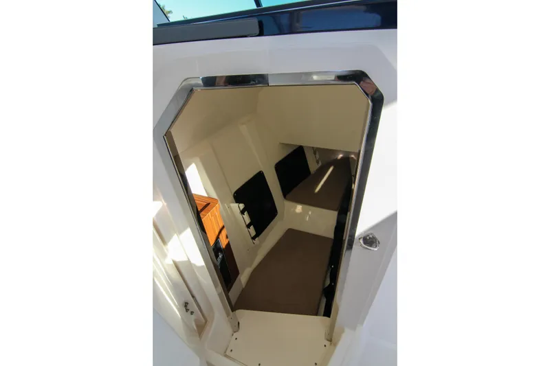 Slide: The Image of 2023 Pursuit DC 295 Dual Console cabin interior with seating and storage. - 14