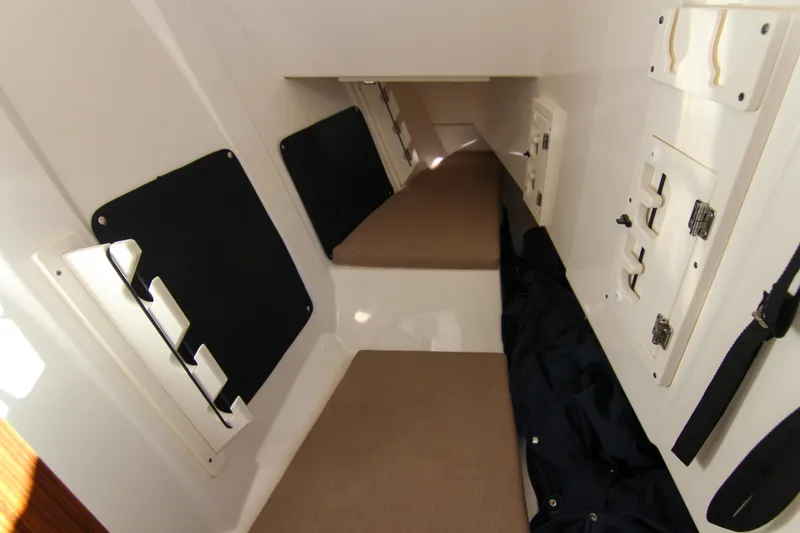 Slide: The Image of 2023 Pursuit DC 295 Dual Console cabin interior with storage compartments and seating. - 16