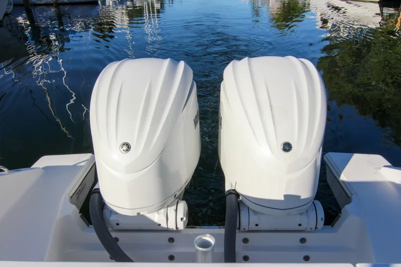 Slide: The Image of 2023 Pursuit DC 295 Dual Console boat with twin outboard engines on water. - 2