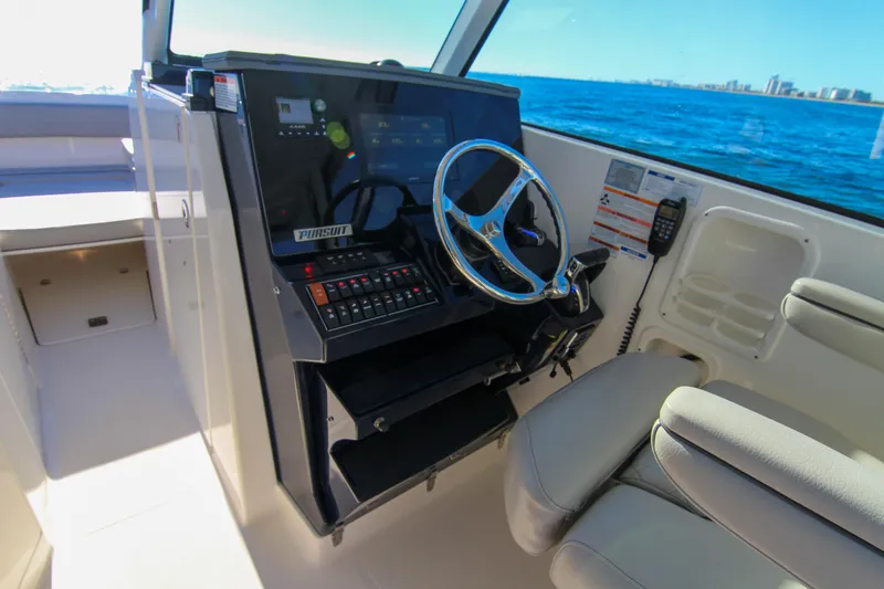 Slide: The Image of 2023 Pursuit DC 295 Dual Console boat interior with steering wheel and control panel. - 25