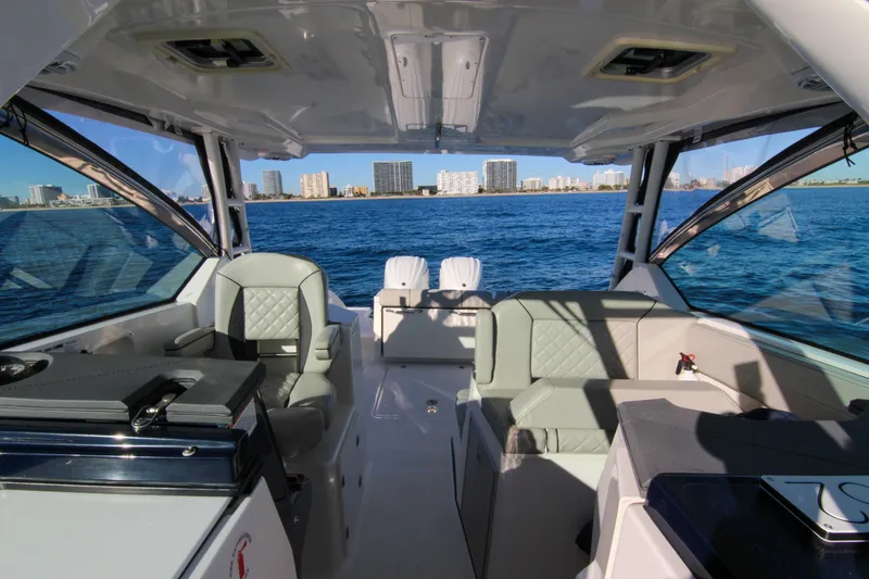 Slide: The Image of 2023 Pursuit DC 295 Dual Console boat interior with ocean and city skyline view. - 26