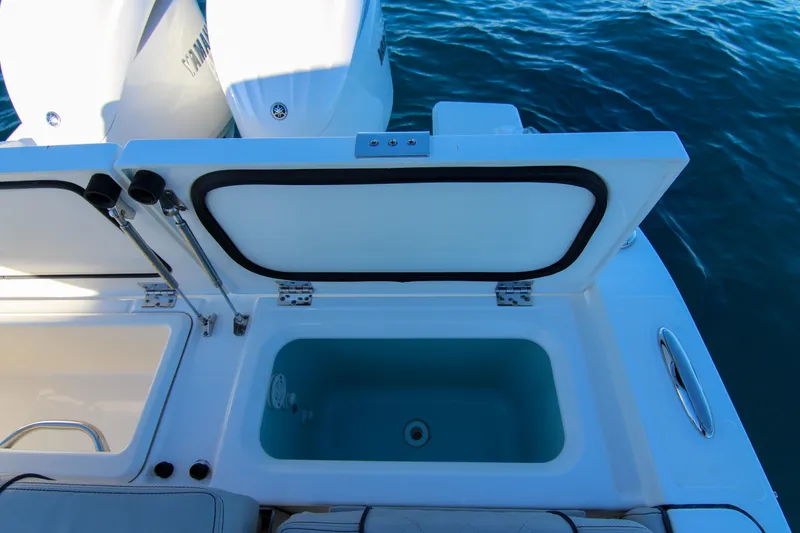 Slide: The Image of 2023 Pursuit DC 295 Dual Console boat with open storage compartment and Yamaha engines. - 28