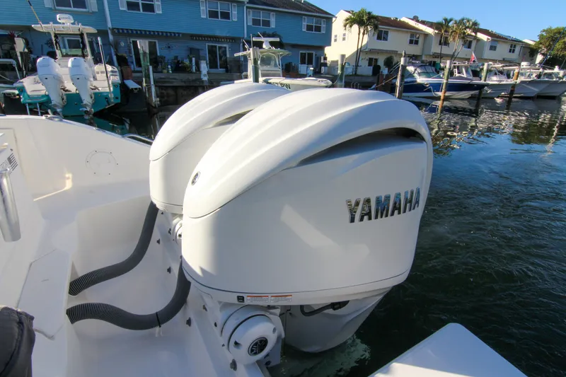 Slide: The Image of 2023 Pursuit DC 295 Dual Console with Yamaha outboard engines docked by waterfront homes. - 3