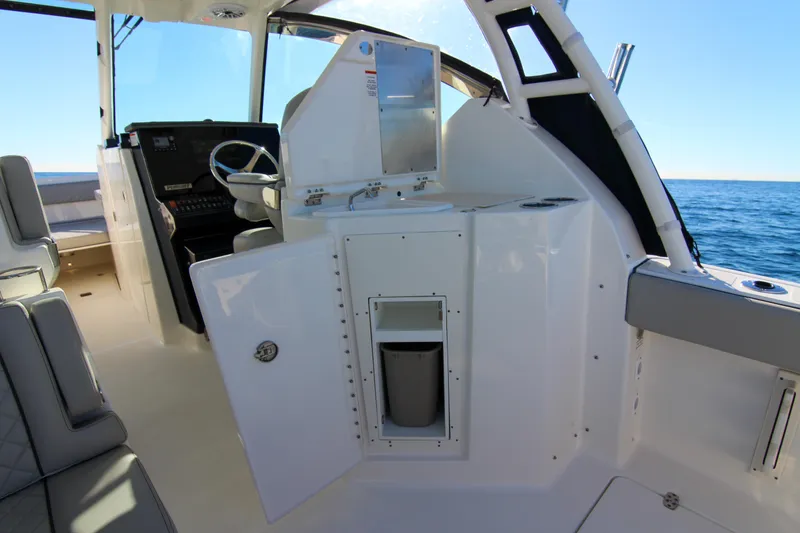 Slide: The Image of 2023 Pursuit DC 295 Dual Console interior with helm and seating, overlooking the ocean. - 31