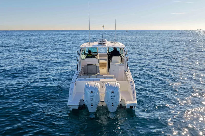 Slide: The Image of 2023 Pursuit DC 295 Dual Console boat on open water, rear view. - 36