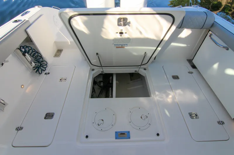 Slide: The Image of 2023 Pursuit DC 295 Dual Console boat deck with open storage compartments. - 4
