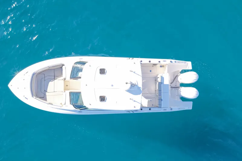 Slide: The Image of 2023 Pursuit DC 295 Dual Console boat on clear blue water, aerial view. - 47