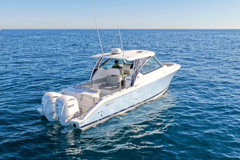 Slide: The Image of 2023 Pursuit DC 295 Dual Console boat cruising on open blue water. - 53