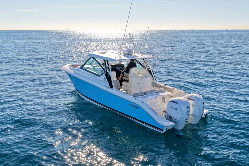Slide: The Image of 2023 Pursuit DC 295 Dual Console boat cruising on open water under clear skies. - 56