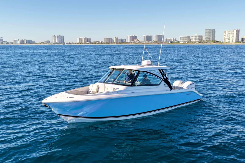 Slide: The Image of 2023 Pursuit DC 295 Dual Console boat on blue ocean with city skyline background. - 59