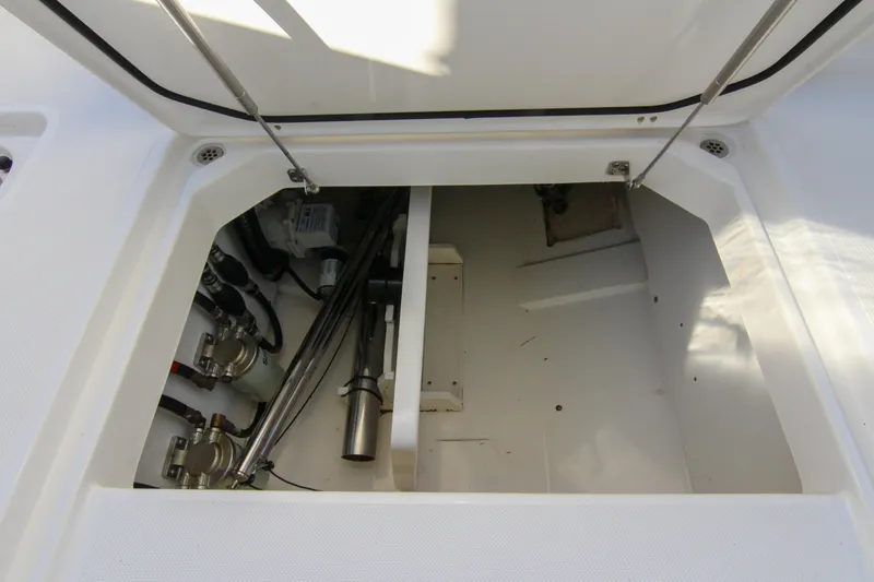 Slide: The Image of 2023 Pursuit DC 295 Dual Console storage compartment with mechanical components visible. - 6