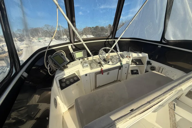 Slide: The Image of 1988 Phoenix 29 SFX Convertible boat cockpit with steering wheel and navigation equipment. - 15