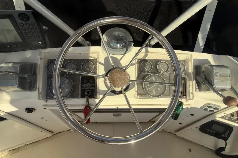 Slide: The Image of 1988 Phoenix 29 SFX Convertible boat dashboard with steering wheel and gauges. - 9