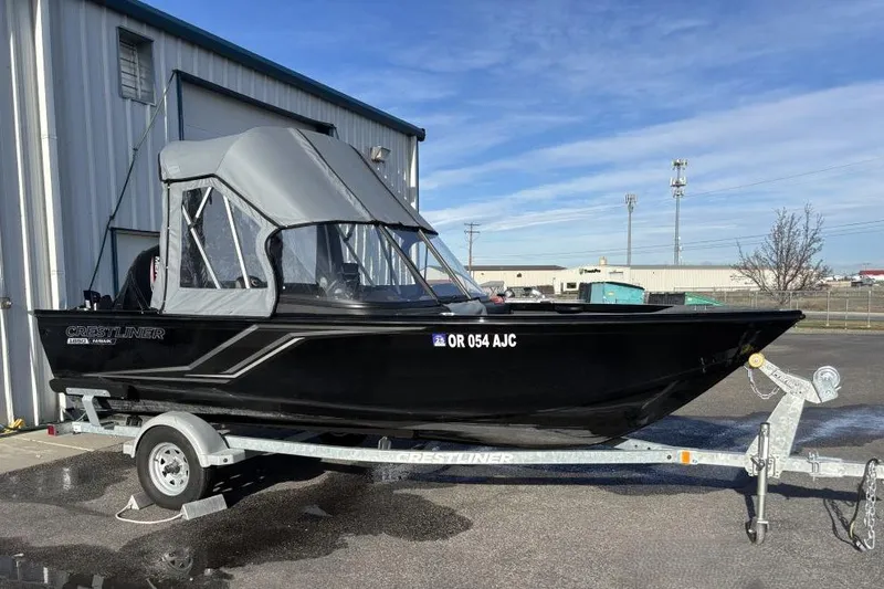 The Image of 2024 Crestliner 1650 Hawk boat on trailer, parked outdoors near a building. - 0