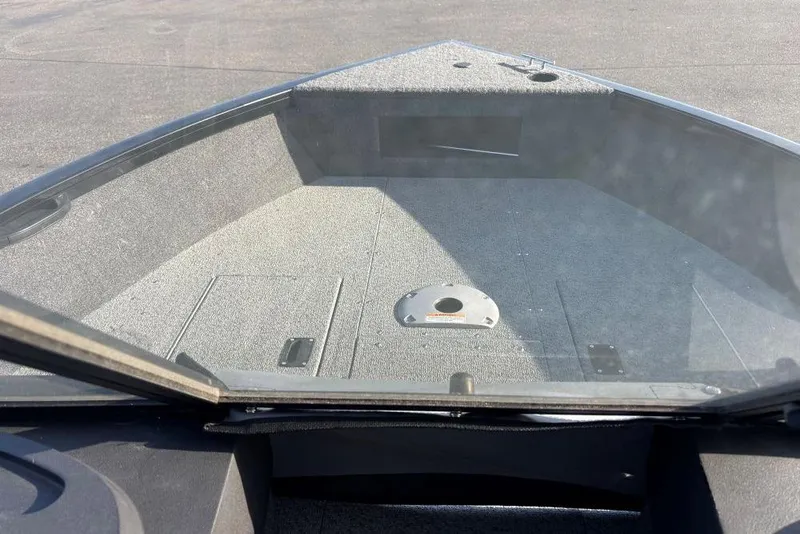 Slide: The Image of 2024 Crestliner 1650 Hawk boat interior with carpeted deck and storage compartments. - 3