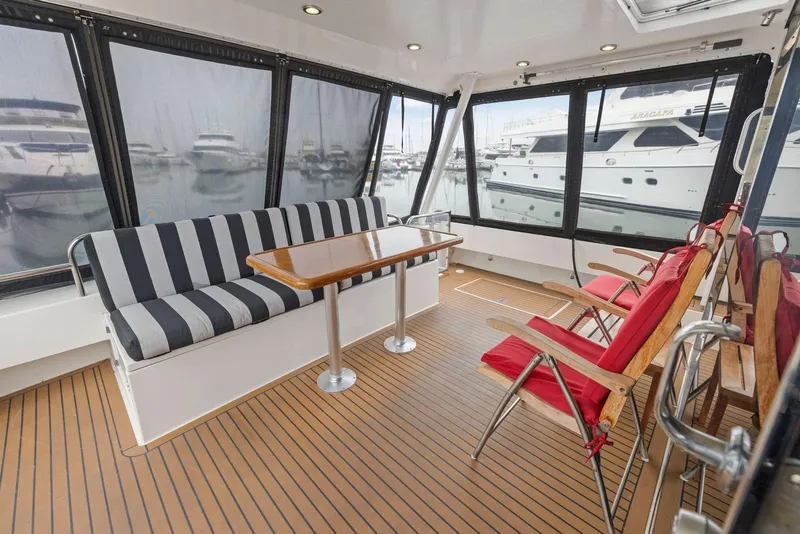 Slide: The Image of Enclosed deck of 1998 Pacific Mariner 65 yacht with seating and table. - 4