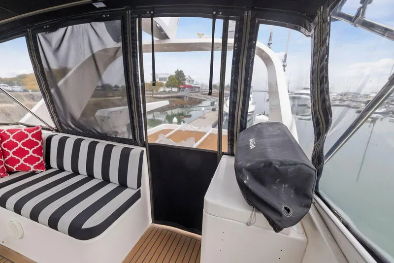 Slide: The Image of Interior view of 1998 Pacific Mariner 65 yacht with striped seating and marina backdrop. - 51