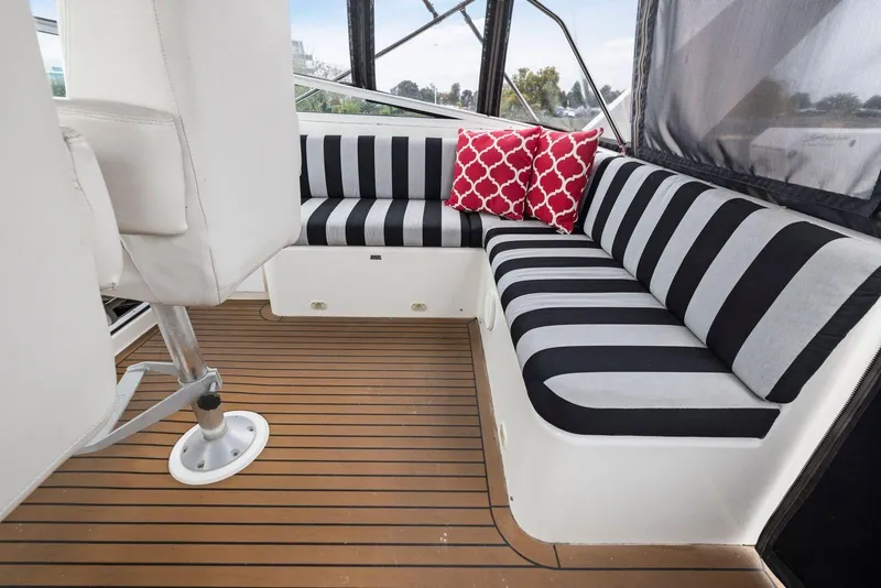 Slide: The Image of Interior of 1998 Pacific Mariner 65 yacht with striped seating and red pillows. - 52