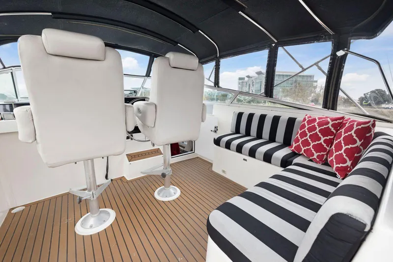 Slide: The Image of Interior of 1998 Pacific Mariner 65 yacht with striped seating and red cushions. - 53
