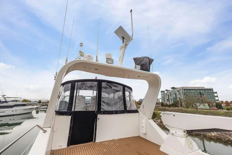 Slide: The Image of 1998 Pacific Mariner 65 yacht with modern deck and marina view. - 56