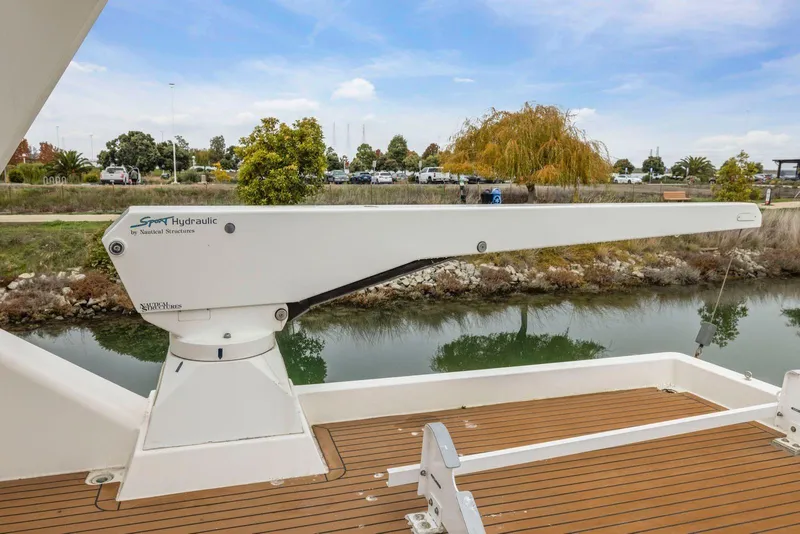 Slide: The Image of Hydraulic crane on 1998 Pacific Mariner 65 yacht, docked by a scenic canal. - 57