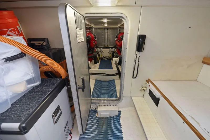 Slide: The Image of Engine room of a 1998 Pacific Mariner 65 yacht, featuring equipment and storage. - 59