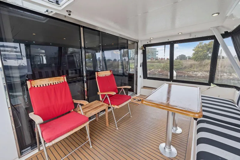 Slide: The Image of 1998 Pacific Mariner 65 yacht interior with red chairs and wooden table. - 6