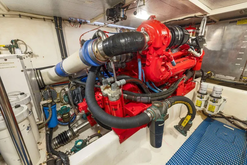 Slide: The Image of Engine room of a 1998 Pacific Mariner 65 yacht with red machinery and pipes. - 62