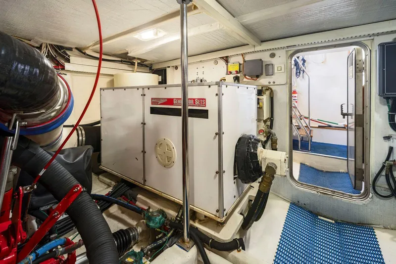 Slide: The Image of Engine room of a 1998 Pacific Mariner 65 yacht, featuring generator and equipment. - 63
