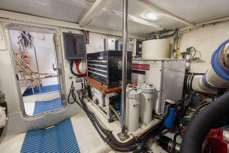 Slide: The Image of Engine room of a 1998 Pacific Mariner 65 yacht, featuring generator and equipment. - 64