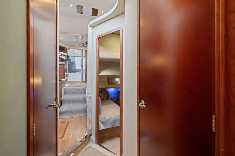 Slide: The Image of Interior view of 2005 Sea Ray 420 Sedan Bridge, featuring cozy cabin and wooden doors. - 11