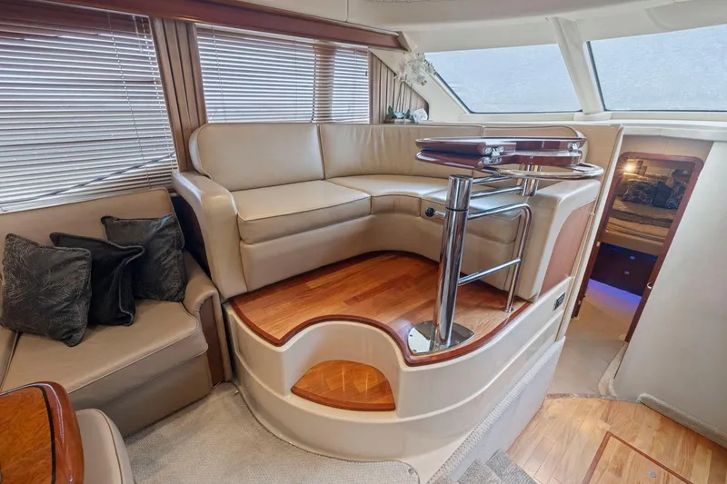 Slide: The Image of Luxurious interior of 2005 Sea Ray 420 Sedan Bridge with elegant seating and wooden accents. - 8