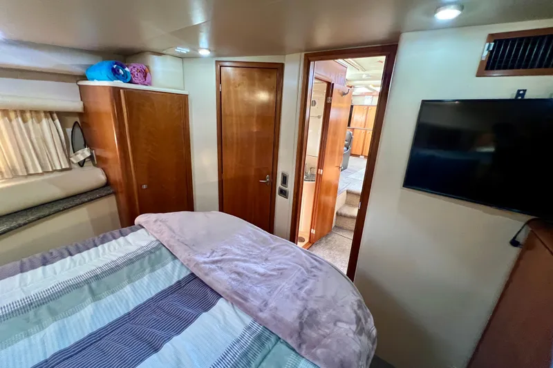 Slide: The Image of Interior of 2004 Meridian 408 Motoryacht bedroom with TV and wooden cabinetry. - 12