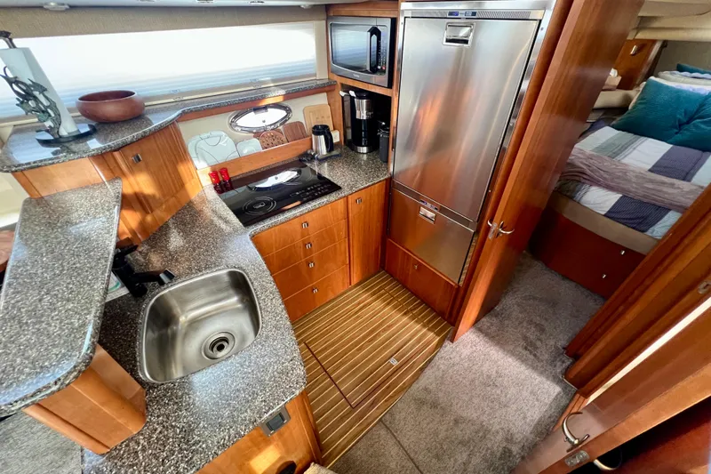 Slide: The Image of Luxurious 2004 Meridian 408 Motoryacht kitchen with modern appliances and cozy bedroom view. - 7