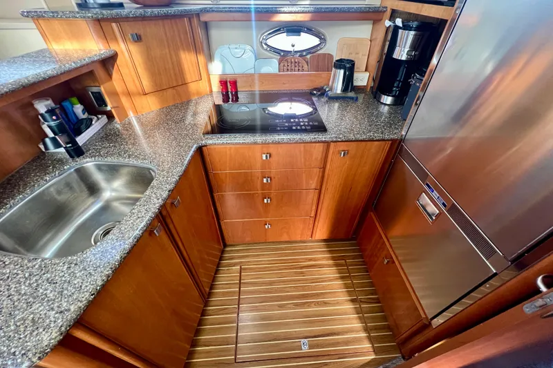 Slide: The Image of 2004 Meridian 408 Motoryacht kitchen with stainless steel appliances and wood cabinetry. - 9