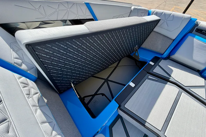 Slide: The Image of 2026 Nautique Super Air Nautique G23 Paragon interior seating with storage compartment open. - 25