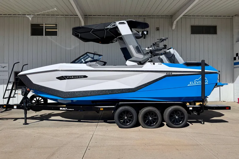 The Image of 2026 Nautique Super Air Nautique G23 Paragon boat on trailer, blue and white design. - 4