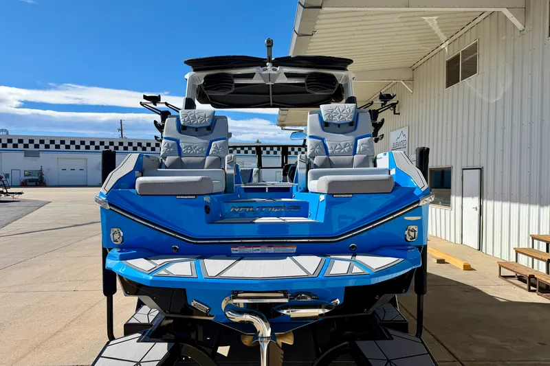 Slide: The Image of 2026 Nautique Super Air Nautique G23 Paragon, blue exterior, docked at marina. - 9