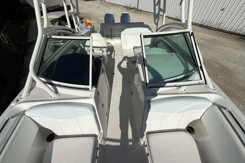 Slide: The Image of 2018 Robalo R247 Dual Console boat interior with open windshield and seating. - 12