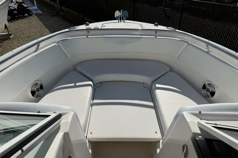 Slide: The Image of 2018 Robalo R247 Dual Console boat interior with cushioned seating and speakers. - 16