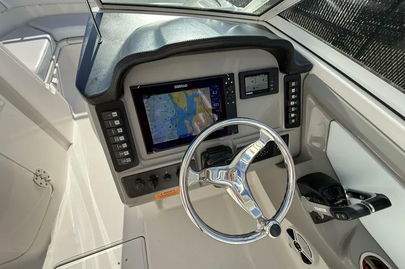 Slide: The Image of 2018 Robalo R247 Dual Console boat dashboard with steering wheel and navigation system. - 7