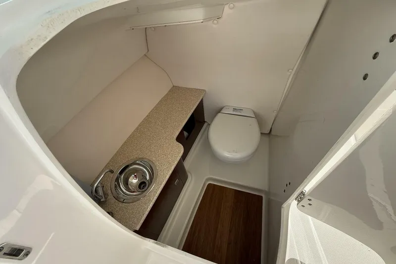 Slide: The Image of 2018 Robalo R247 Dual Console boat interior with sink and toilet. - 9