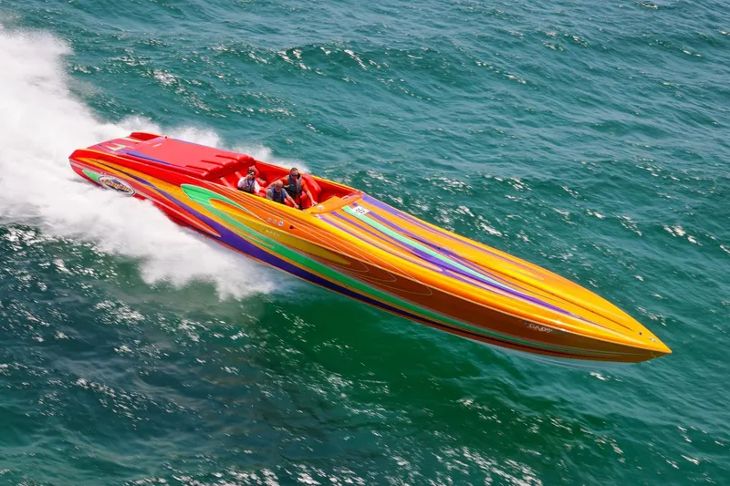 The Image of 2005 Outerlimits 51 Sport Yacht speeding on ocean with vibrant, colorful design. - 0