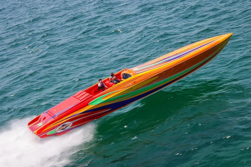 Slide: The Image of 2005 Outerlimits 51 Sport Yacht speeding on open water, vibrant multicolored design. - 1