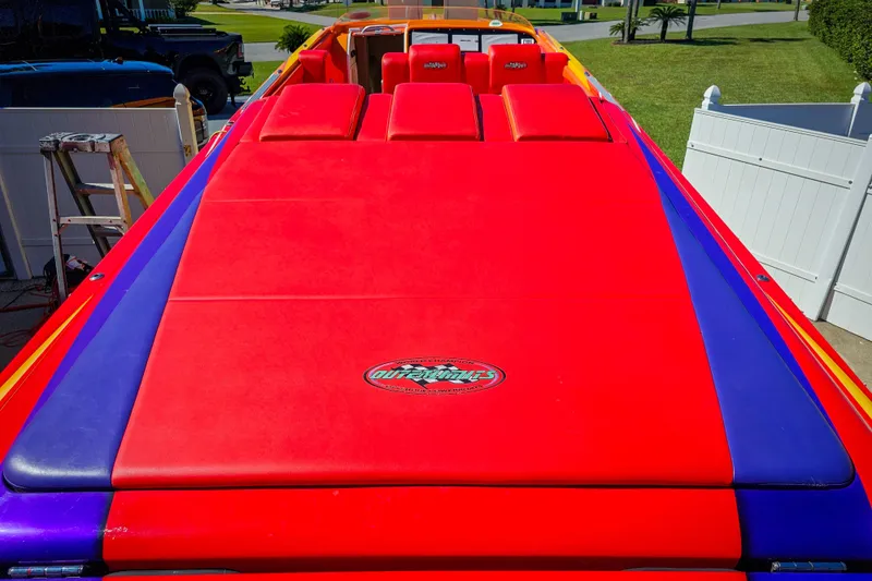 Slide: The Image of 2005 Outerlimits 51 Sport Yacht with vibrant red and blue upholstery, parked outdoors. - 11