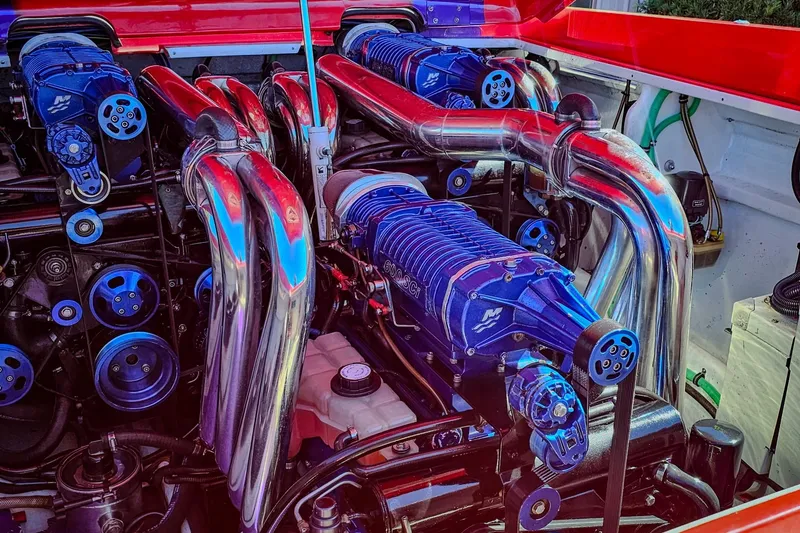 Slide: The Image of Engine of a 2005 Outerlimits 51 Sport Yacht with polished components and blue accents. - 30