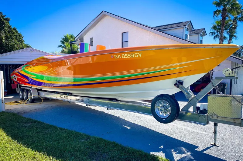 Slide: The Image of 2005 Outerlimits 51 Sport Yacht with vibrant orange and multicolor design on a trailer. - 4